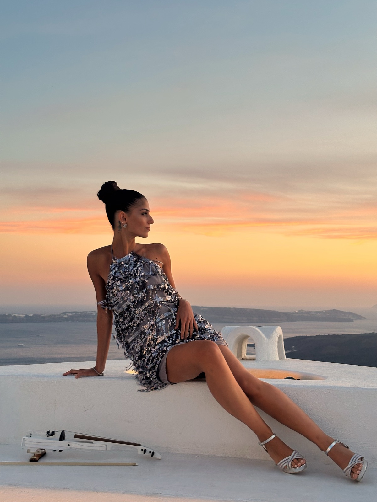 Marvi seated on a Santorini rooftop at golden hour